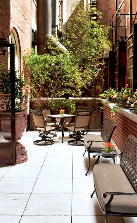garden furniture on a balcony with potted plants placed around