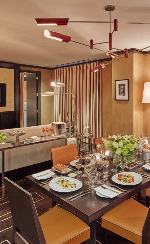 Suite with fireplace, couch, chair, and table with dinner served